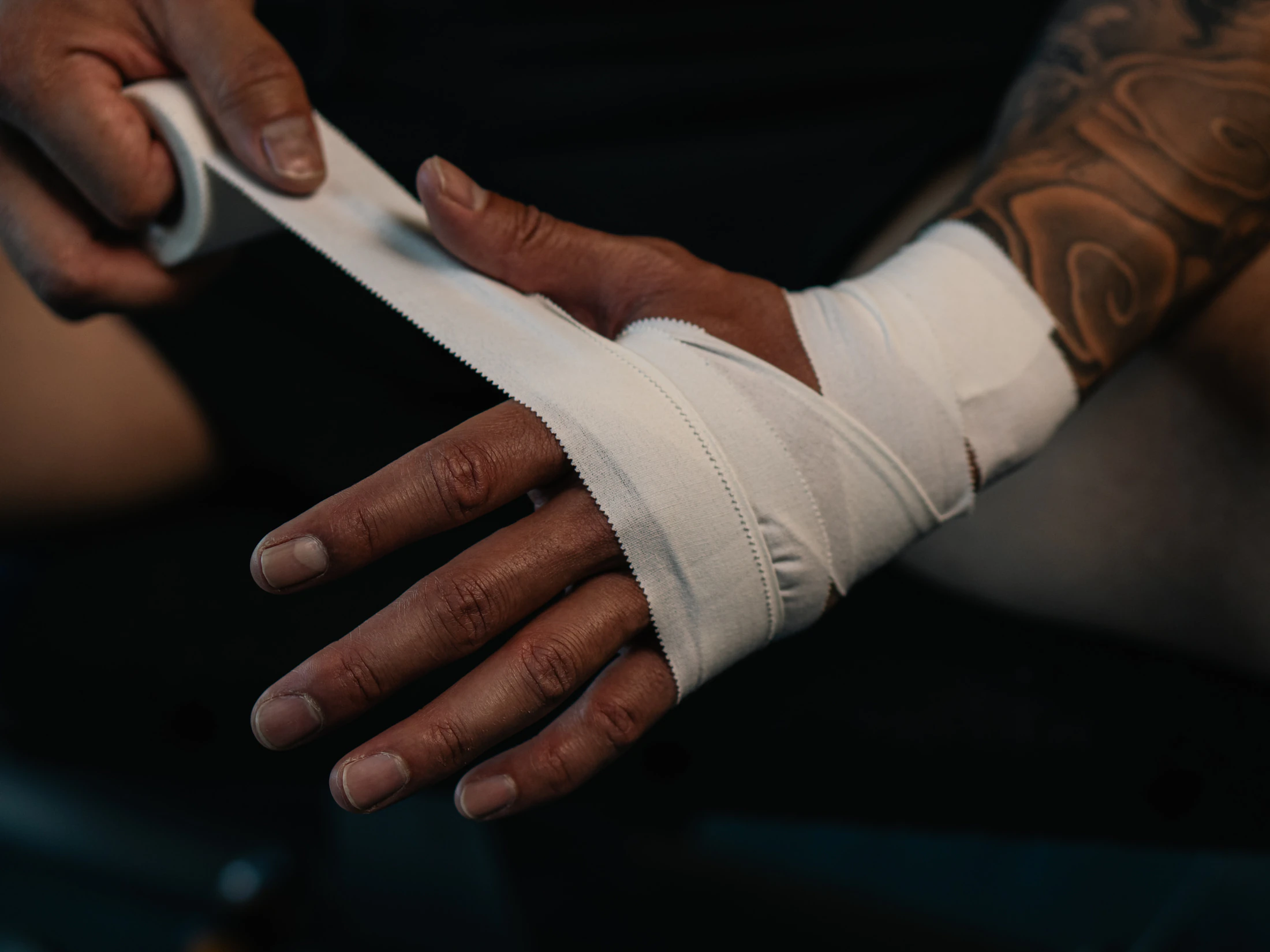 Hands wrapping tape around a wrist